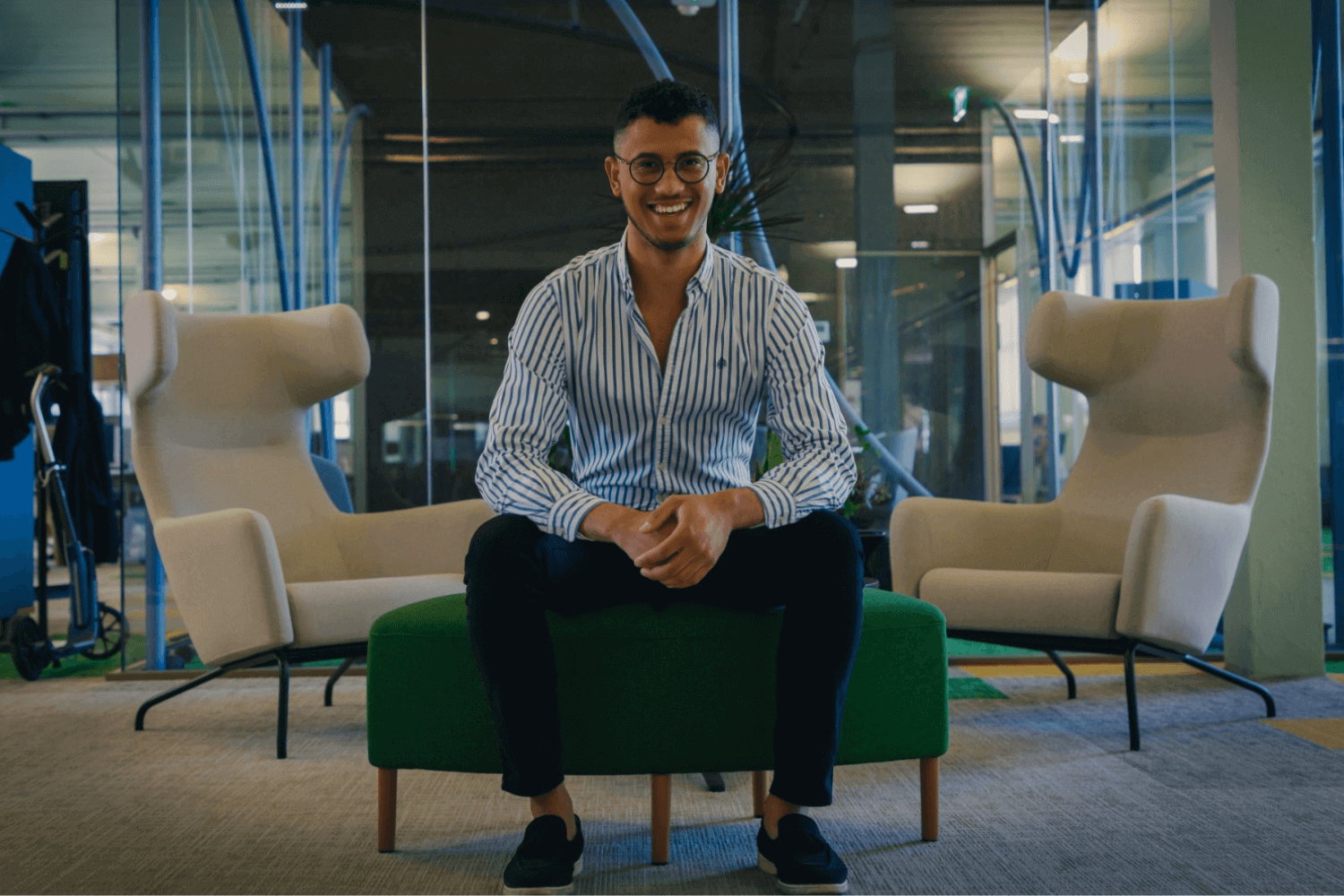 A man sat on a bench wearing a blue shirt. 