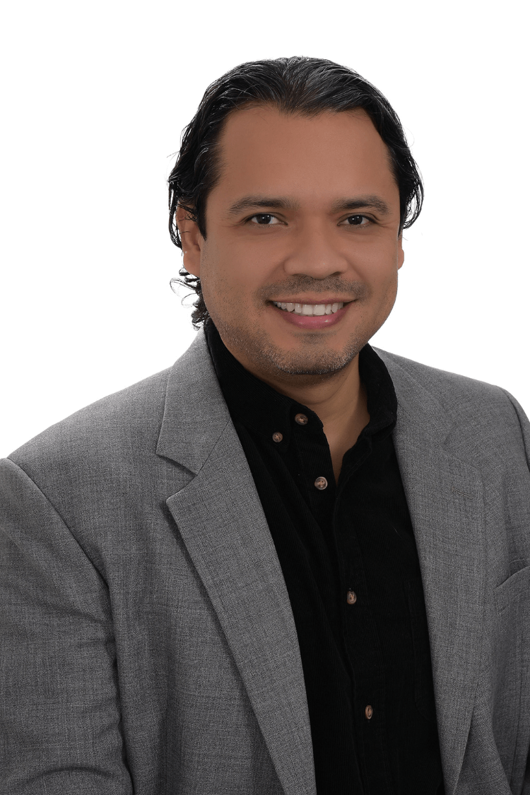 A man wearing a dark shirt and grey jacket 