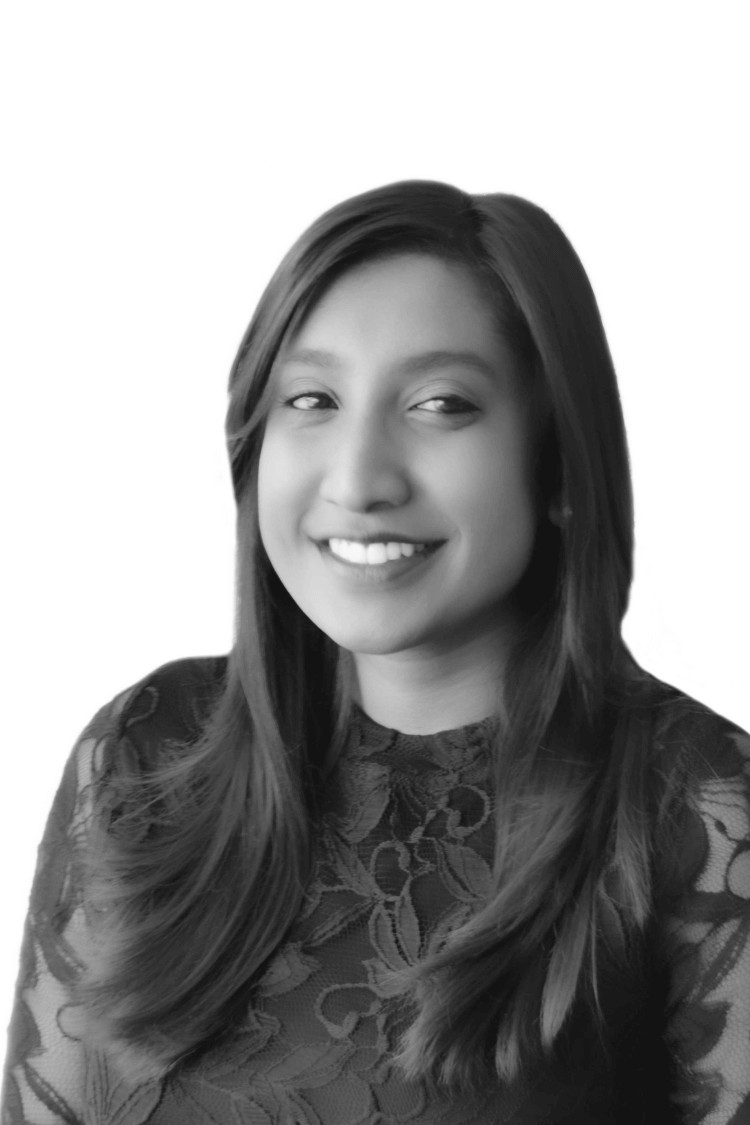A black and white images of a young woman with long hair smiling at the camera. 